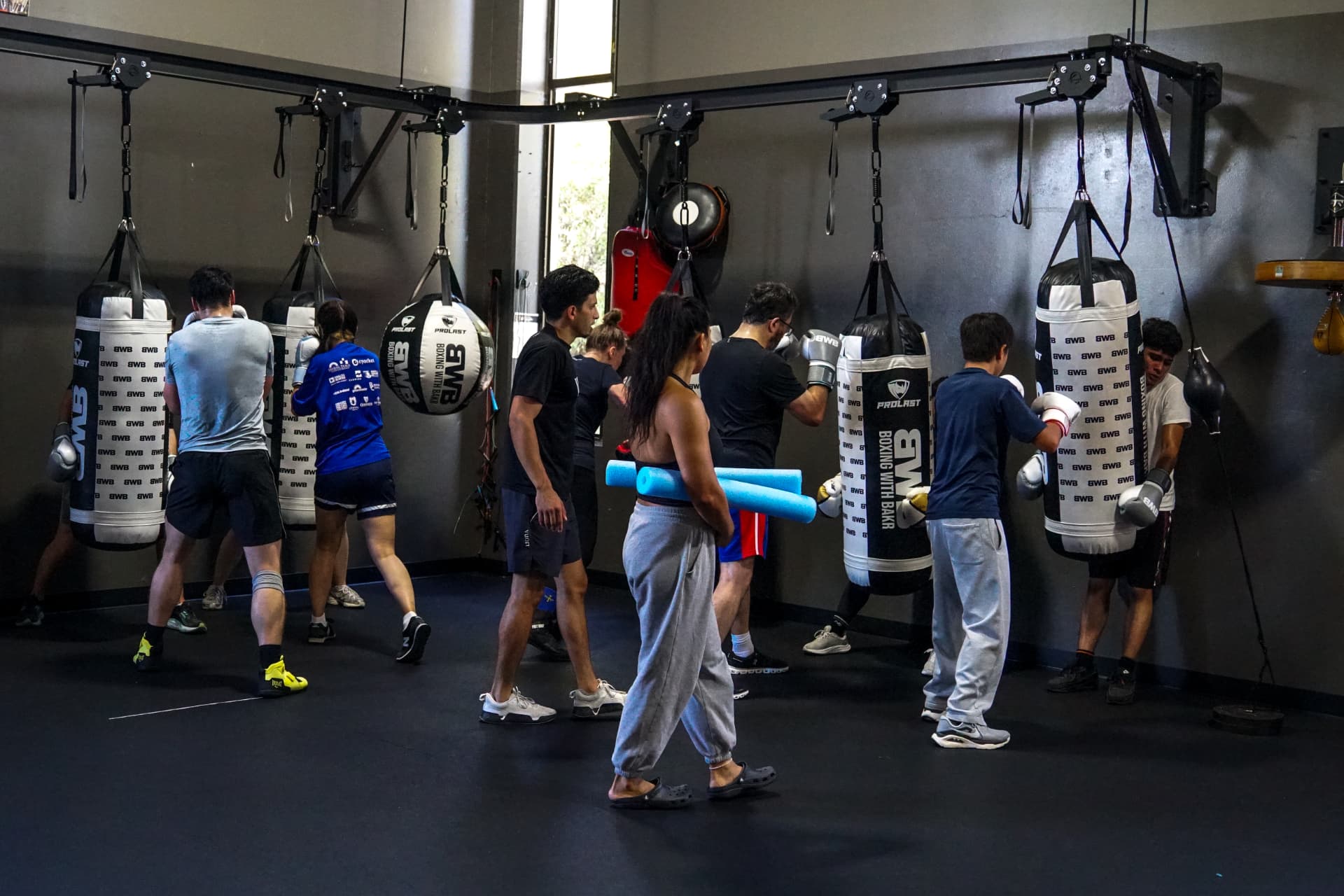 Group class working heavy bags together at Boxing With Bakr in Palo Alto