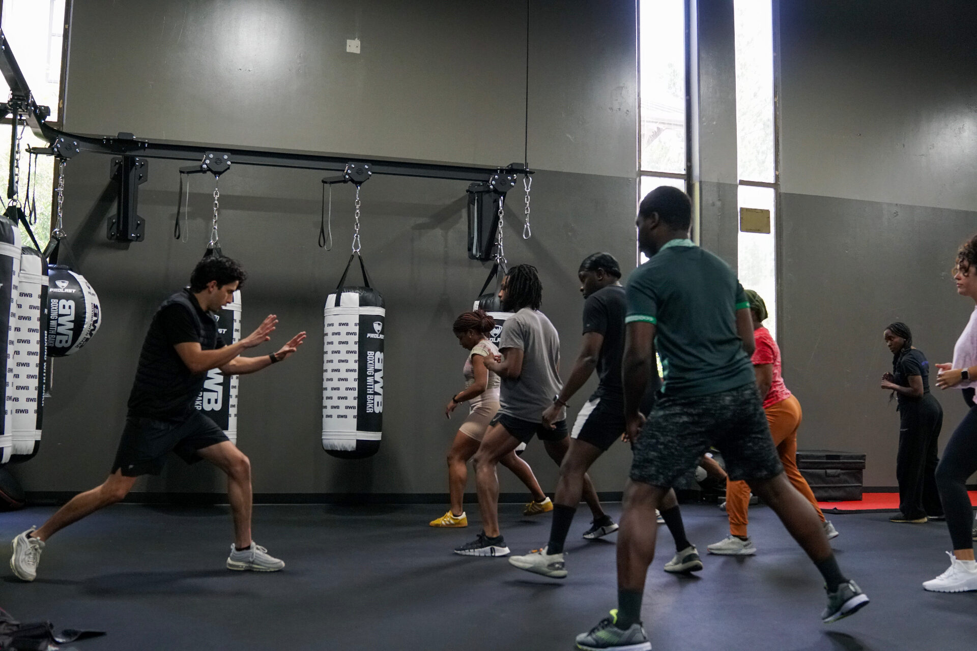 Small-group class running a footwork drill on the gym floor